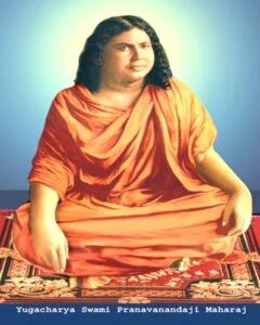 Yugacharya Srimat Swami Pranavananda Ji Maharaj seated in saffron robes